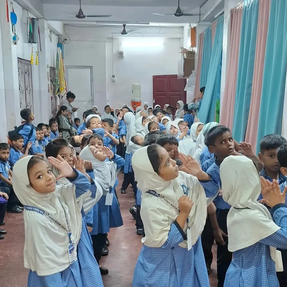 LKG children in uniform raising their hands during an Annual Day rehearsal
