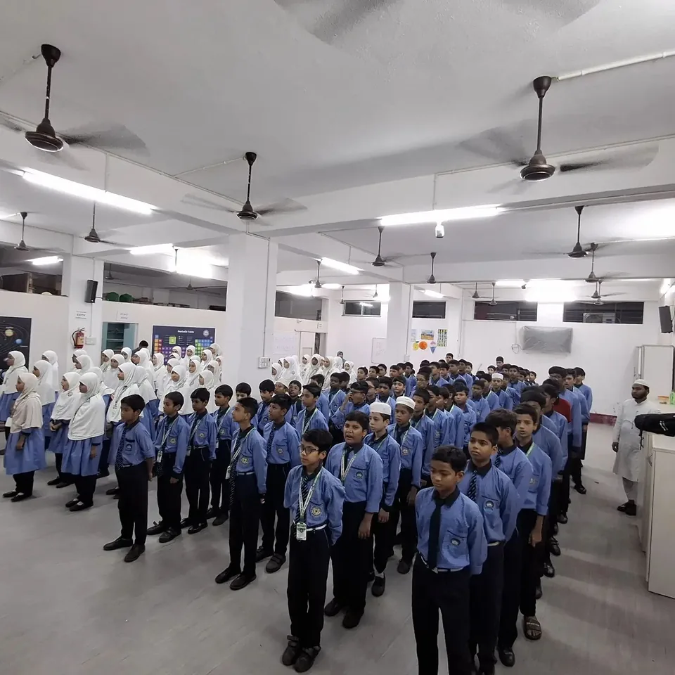 Students of The Noble Mission School standing in rows inside the assembly hall during the morning assembly